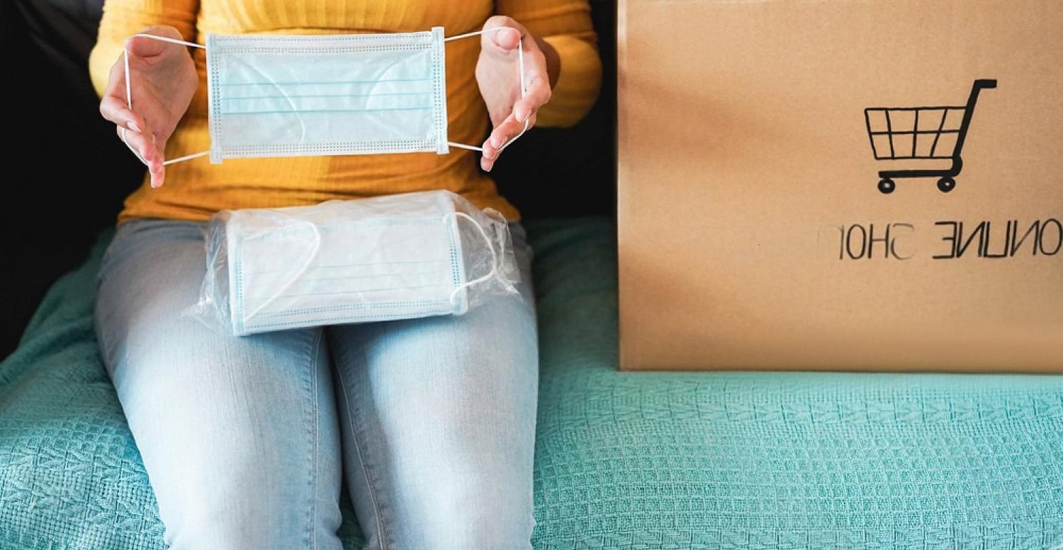 Person holding a product beside an online shop parcel, illustrating online rental purchases in the UAE